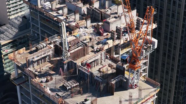 Construction workers and crane building skyscraper in downtown area, showcasing urban development, engineering and real estate growth in modern cityscape
