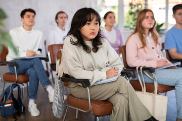 Fototapeta premium High school students sit at their desks and listen carefully to the teacher at the lesson at school