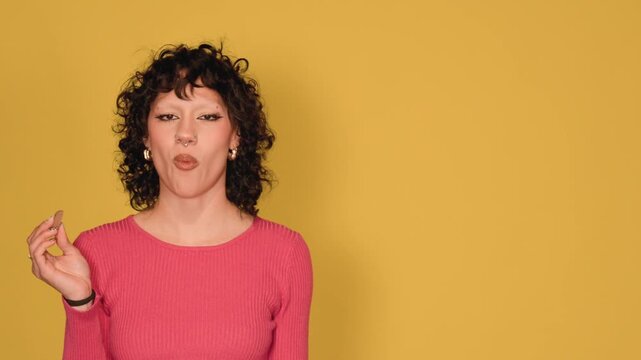 Young woman chewing gum on yellow background