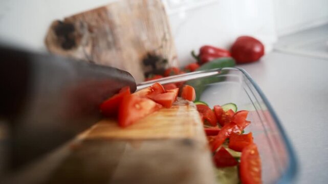 Chef Knife Drops Chopped Tomatoes Into A Greek Salad From A Wooden Cutting Board In The Kitchen, Object POV camera angle shot