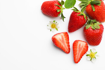 Naklejka premium Ripe strawberries, leaves and flowers on white background, flat lay. Space for text