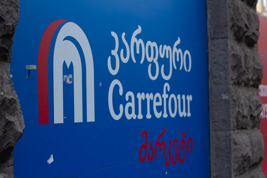 Tbilisi, Georgia - May 19, 2026: Horizontal street city photo. Blue banner with Georgian shop logo Carrefour market on mass market grocery store wall. Sale, 11 november, Black friday, welcome concept