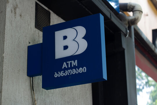 Tbilisi, Georgia - May 19, 2026: Horizontal street photo close up. Logo of Basisbank on blue square board. GEL bill, lari. Concept of ATM, pay tax, credit, cash money, loan, debt, plastic card, budget