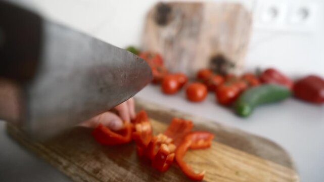 Male Hands Cut Sweet Red Bell Pepper With A Large Kitchen Knife On A Cutting Board In A Kitchen, Object POV camera angle shot