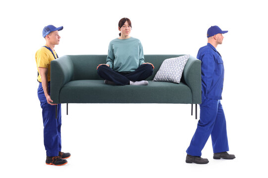 Movers carrying sofa with girl sitting on it against white background