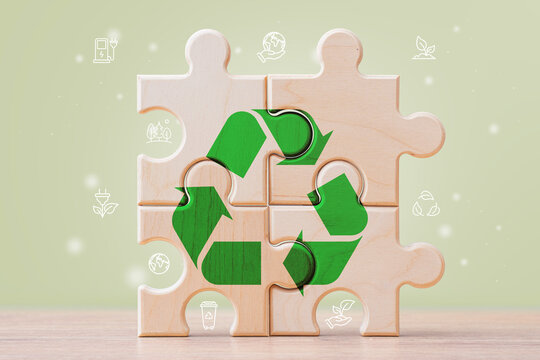 Recycling symbol on wooden puzzle with eco icons and green background. Sustainability, circular economy and environmental protection concept for ESG strategy, renewable energy and green business.