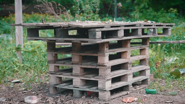 Parallax Side Shot: Abandoned Makeshift Picnic Table Made from Old Wooden Pallets with Broken Glass and Litter | Neglected Outdoor Furniture in Overgrown Area | Urban Decay Scene