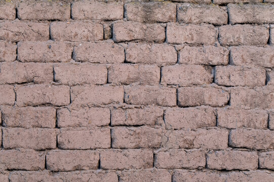 Rustic adobe brick wall texture, traditional rural construction background in Macusani, Peru.