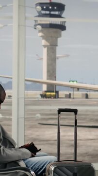 Vertical video Going to boarding gate, departure board timetable and multiracial tourists in airport hub. Reading time on FIDS display, leaving for boarding call and diverse group of travelers
