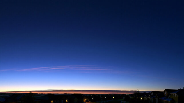 Panoramic twilight sky with deep blue gradient and warm orange horizon glow over city silhouette, dusk atmosphere