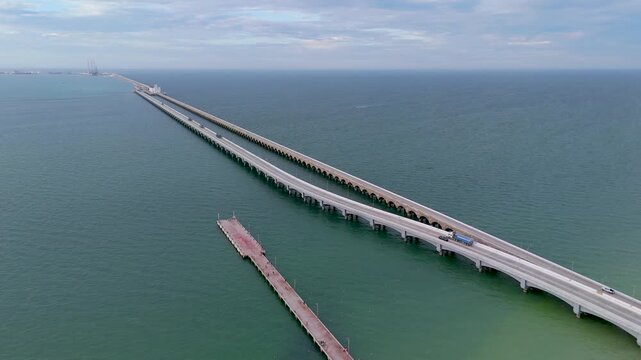 Aerial landscape shot captures a perspective of the immense arched viaduct pier stretching out to sea from the coast of Progreso, Mexico. 