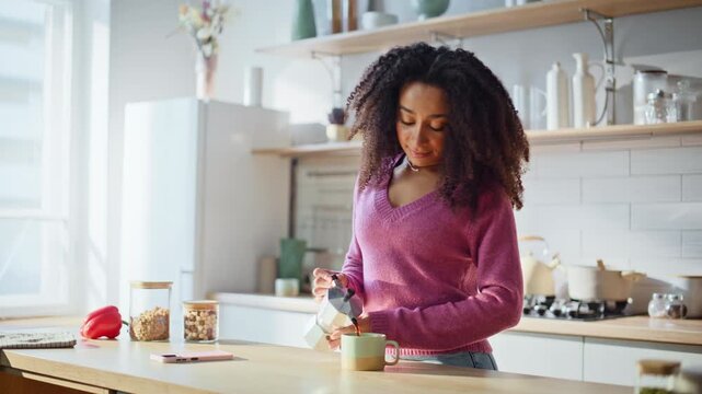Lady pouring freshly brewed coffee sniffing aroma standing kitchen closeup.