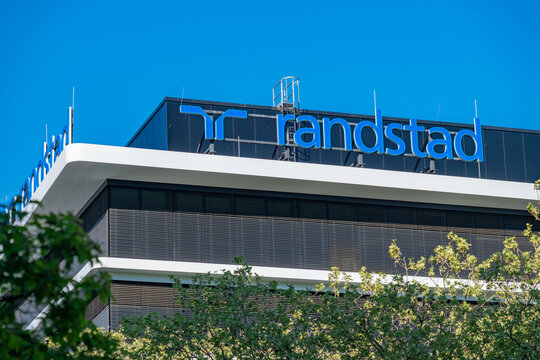 Randstad logo modern office building, Dutch HR agency, staffing solutions, temporary work, trust uncertainty recruitment, corporate workforce mobility post-pandemic Europe and Asia, Eschborn, GERMANY