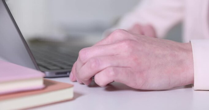 Woman connecting USB flash drive to laptop at desk, closeup