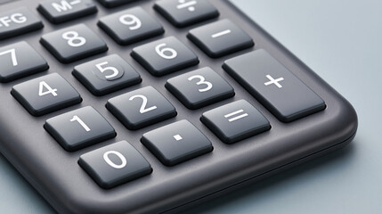 Fototapeta premium Close-up of a dark gray calculator keypad with numbers and symbols clearly visible on a light blue-gray surface