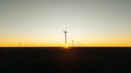 Fototapeta premium Wind farm at sunset symbolizing clean energy transition and sustainable industrial development.