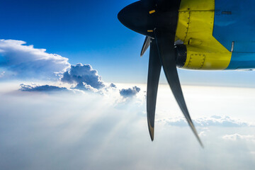 Airplane propeller and engine view above clouds in blue sky aerial travel © macknimal