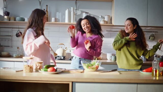 Multiracial friends dancing kitchen holding tools enjoying funny cooking process
