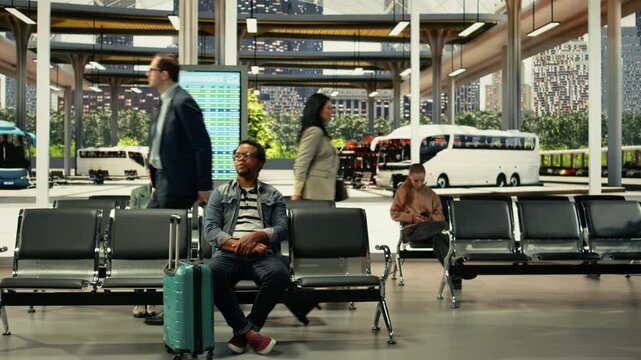 Multiethnic crowd of travelers waiting before intercity bus departure, inside station hall hub. Passengers with carry-on luggage checking timetable information, long-distance travel.