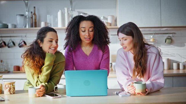 Girls friends chatting laptop standing kitchen closeup. Happy multiracial group