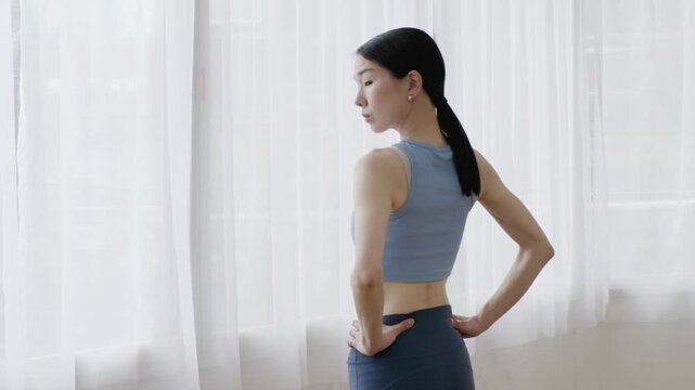 Asian Woman in Yoga Wear Checking Body Shape in Mirror