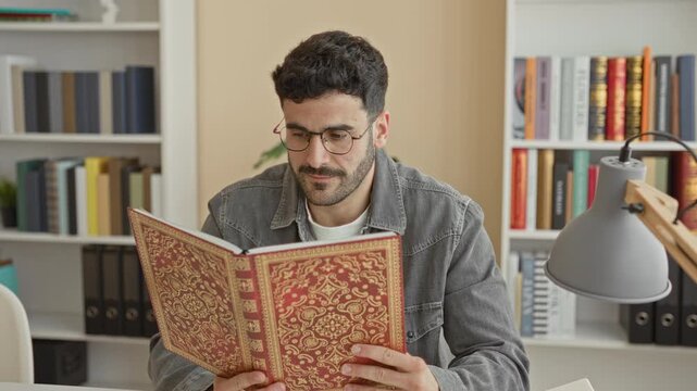 Man reading ornate red book, finger to lips for silence in building study with shelves and lamp; contemplation.