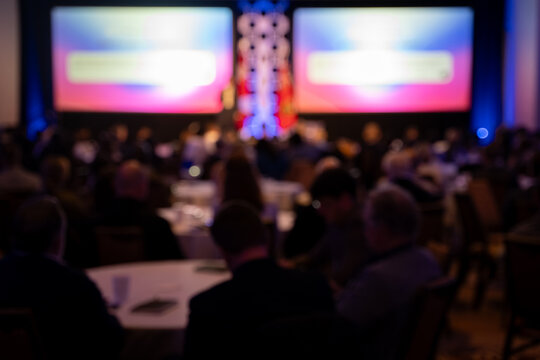Blurred audience at corporate conference presentation event.