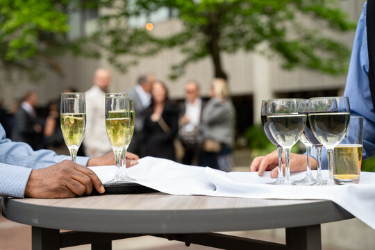 People drinking champagne at outdoor corporate networking event.