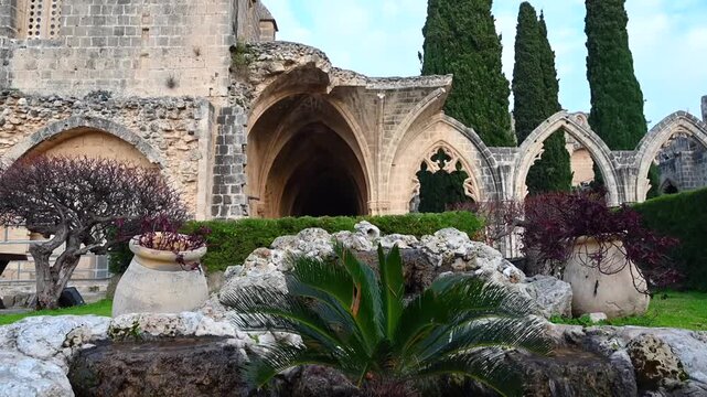 Bellapais abbey courtyard with historic stone gothic ruins and ornamental fountain.