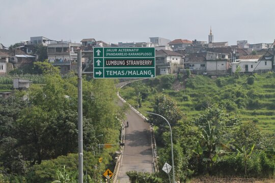 Directional Road Sign Pointing to Lumbung Strawberry and Temas Malang Overlooking Indonesian Green Countryside Village