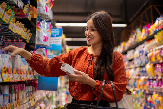 Woman shopping for product at grocery store aisle