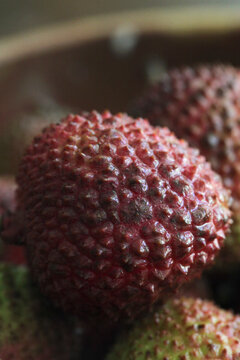 Close-up view of fresh lychees with their bumpy red skin