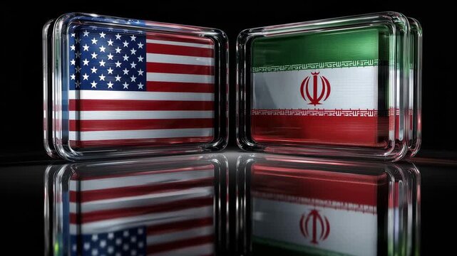 Two glass blocks display the flags of Iran and the USA facing each other at night. The colors reflect and create a striking image of the nations.