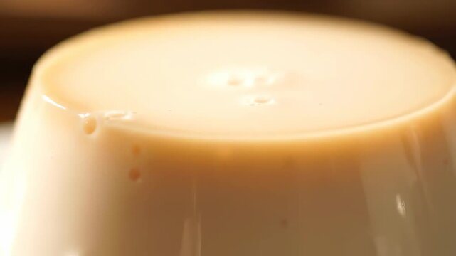 Macro close-up of silky creamy pudding dessert surface. tempting gourmet flan or panna cotta texture detail.