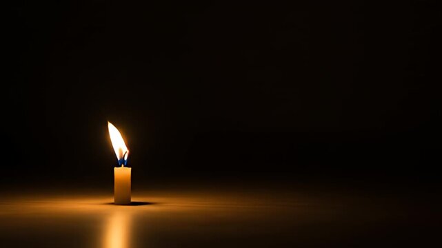 A single candle with a bright flame stands against a dark, blurred background