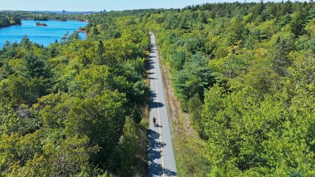 Aerial View Cycling Road Through Forest Halifax Nova Scotia Canada Cyclist Riding On Curved Path Green Nature Park Outdoor Sport Scene 4K