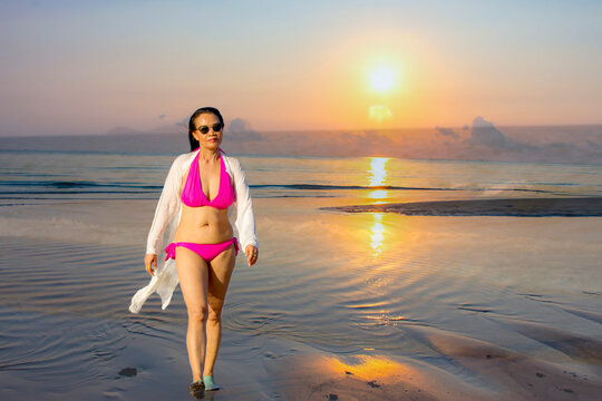 Woman with pink bikini and sunrise