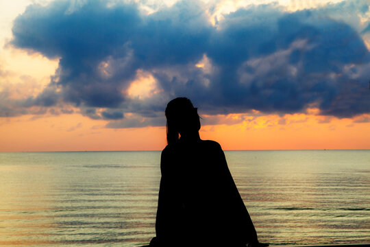 Woman in swimsuit and silhouette sunrise