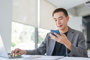 Fototapeta premium Young Business man holding Smartphone&nbsp;working mobile devices. cell telephone technology e-commerce smartphone for business work