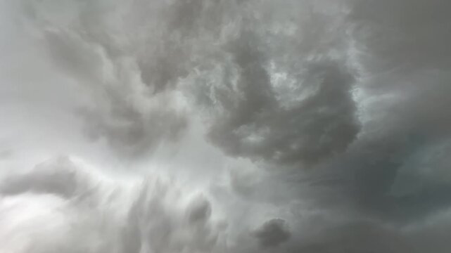 Moving storm cloud formations over agricultural prairie landscape with dramatic natural weather scene