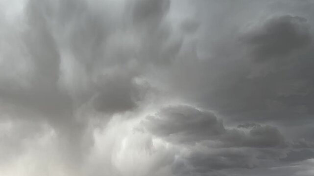 Dark weather system and dramatic cloud formations over open countryside prairie landscape