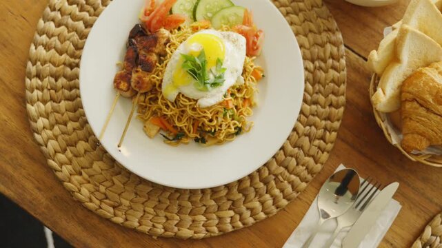 Traditional Indonesian mie goreng served with fried egg, vegetables, and savory spices.