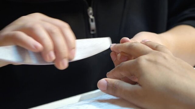 Nail care session in a salon with hand filing techniques