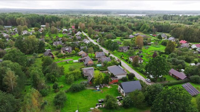 Overcast aerial of Skrunda, residential homes trees and small town landscape