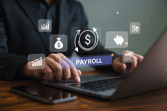 Accountant using laptop computer for payroll processing with digital financial and banking icons over wooden desk.