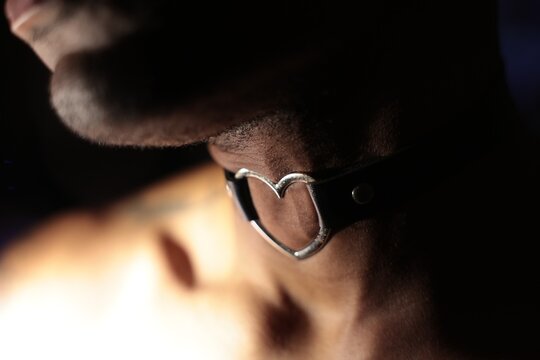 A person wearing a leather choker around their neck.