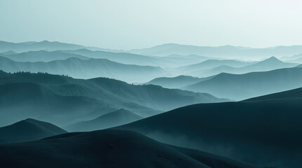 Fototapeta premium Misty layered mountain landscape with soft teal tones and distant ridgelines