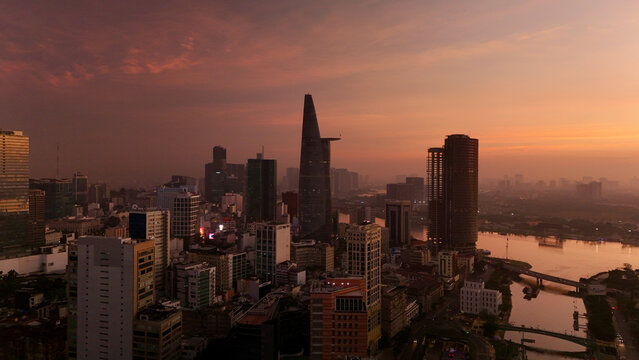 Ho Chi Minh City, Vietnam &ndash; 4K aerial sunrise drone view of downtown skyline with modern skyscrapers, dense urban housing, busy streets and morning traffic along the Saigon River in Southeast Asia