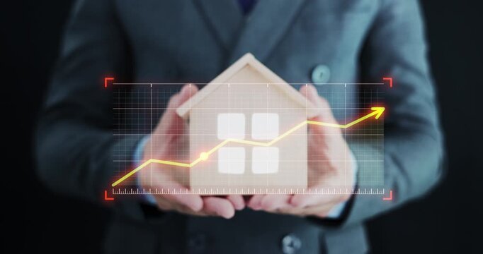 Real estate investment growth, business professional in suit holding model house with upward-trending financial graph overlay. Symbolizes rising property values, successful real estate investment.
