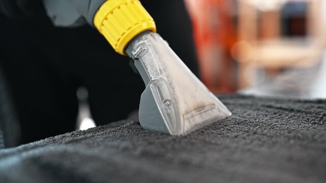 Professional car floor mat wet vacuum cleaning process with extractor tool.